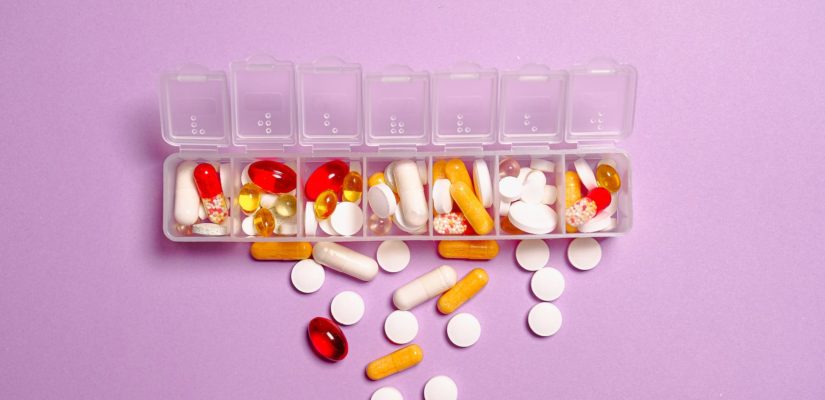 foto pillole di farmaci sul contenitore di plastica bianca